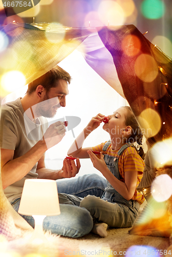 Image of family playing tea party in kids tent at home