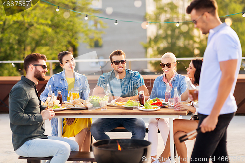 Image of happy friends having bbq party on rooftop