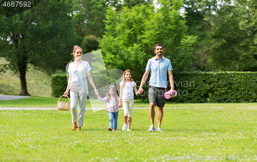 Image of family with picnic basket walking in summer park