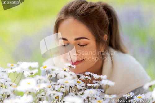 Image of close up of woman smelling chamomile flowers