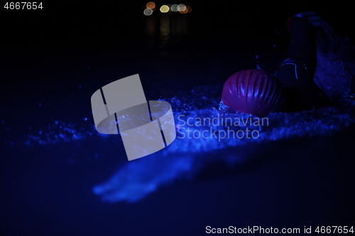 Image of real triathlon athlete swimming in dark night