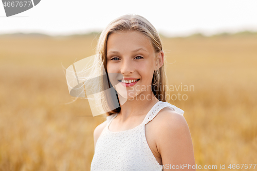 Image of smiling young girl on cereal field in summer