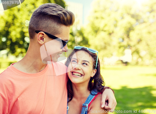 Image of happy teenage couple looking at each other in park