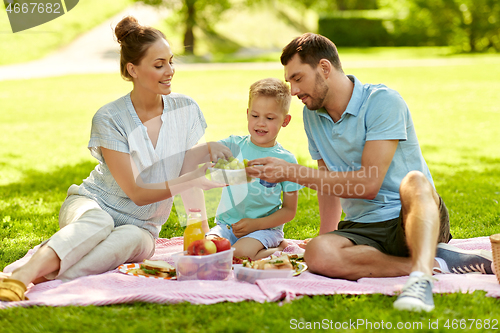 Image of happy family having picnic at summer park