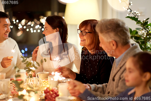 Image of family with sparklers having tea party at home