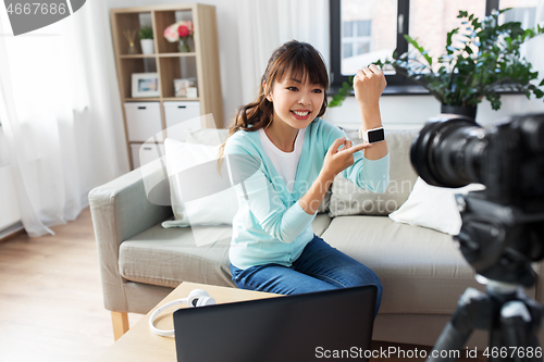 Image of asian blogger makes video blog of smart watch