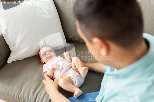 Image of middle aged father playing with baby at home