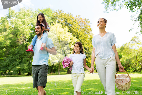 Image of family with picnic basket walking in summer park