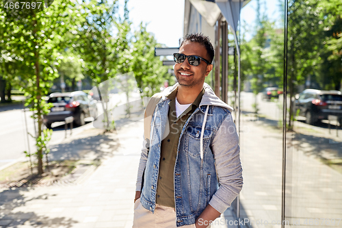 Image of indian man with backpack walking along city street