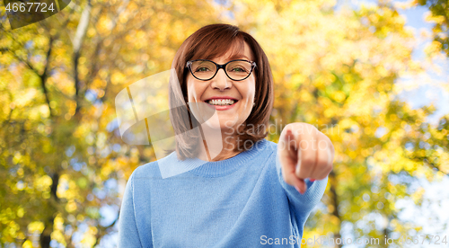 Image of senior woman in glasses pointing finger to you