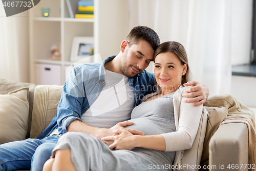 Image of man hugging pregnant woman at home