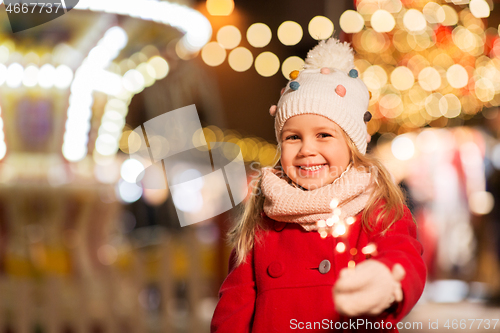 Image of happy girl with sparkler at christmas market