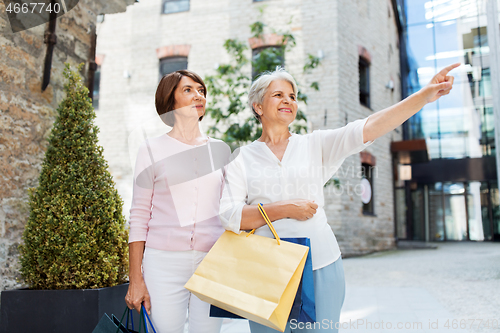 Image of senior women with shopping bags walking in city