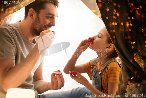 Image of family playing tea party in kids tent at home