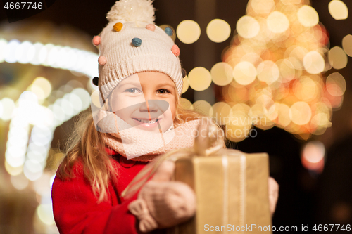 Image of happy girl with gift box at christmas market