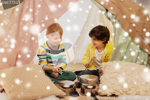 Image of boys with pots playing music in kids tent at home