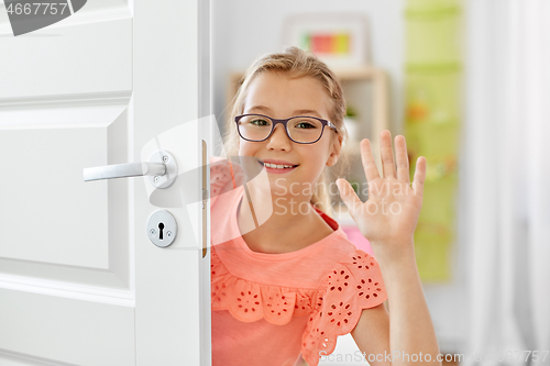 Image of happy smiling beautiful girl behind door at home