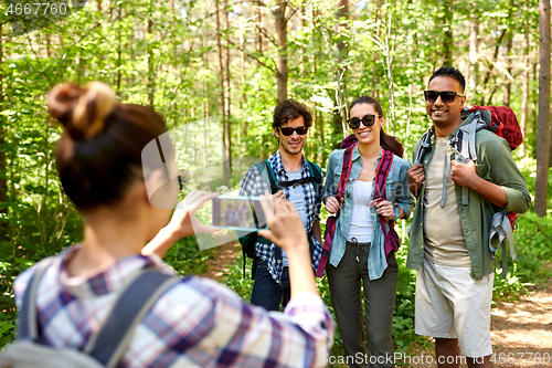 Image of friends with backpacks being photographed on hike