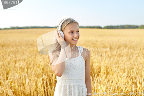 Image of happy girl in headphones on cereal field in summer