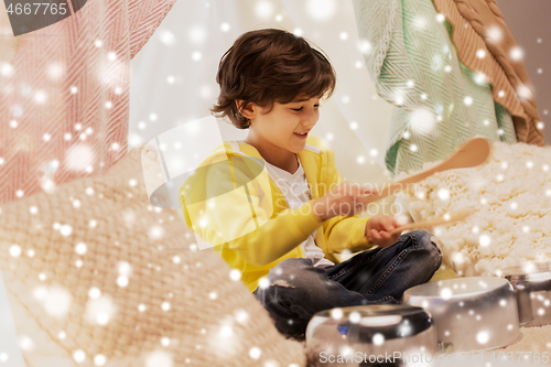 Image of boy with pots playing music in kids tent at home