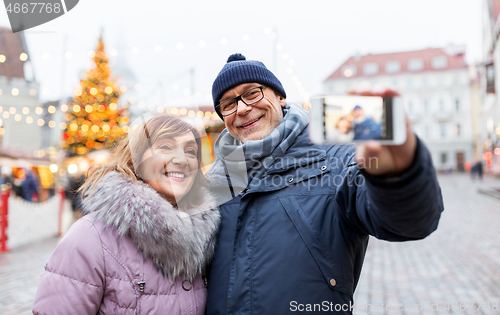 Image of senior couple taking selfie at christmas market