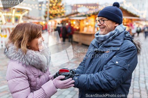 Image of senior couple with mulled wine at christmas market