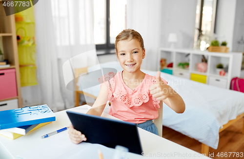 Image of girl with tablet pc and showing thumbs up at home