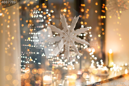 Image of paper snowflake decoration hanging on window