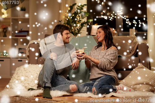 Image of happy couple with gift box at home