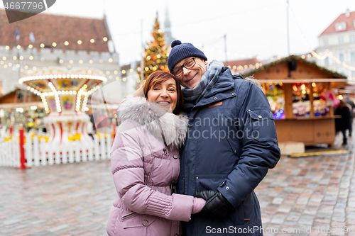 Image of happy senior couple hugging at christmas market