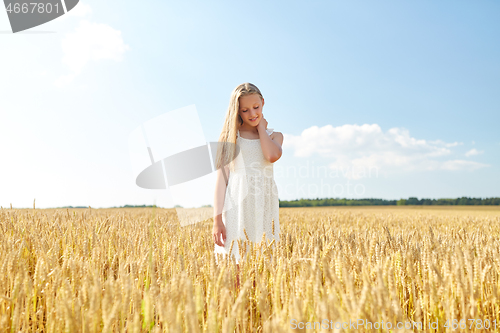 Image of smiling young girl on cereal field in summer