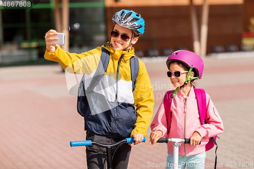 Image of happy school kids with scooters taking selfie