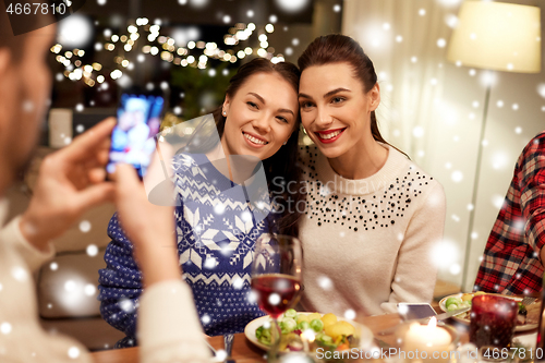 Image of friends having christmas dinner and taking picture