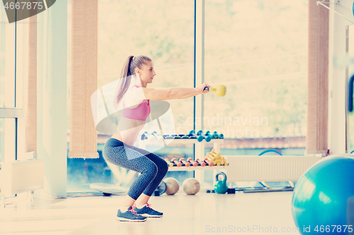 Image of weights lifting  and working on her biceps in a gym