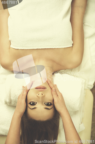 Image of woman getting face and head  massage in spa salon