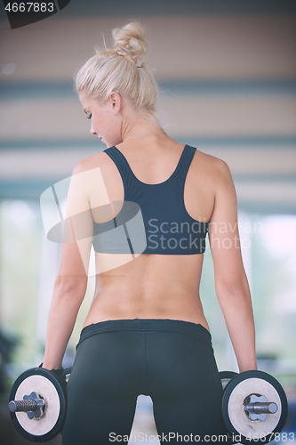 Image of lifting some weights and working on her biceps in a gym