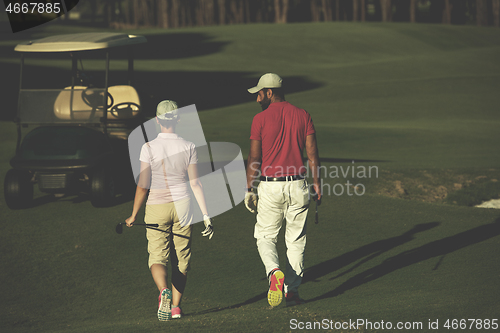 Image of couple walking on golf course