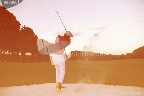 Image of golfer hitting a sand bunker shot on sunset