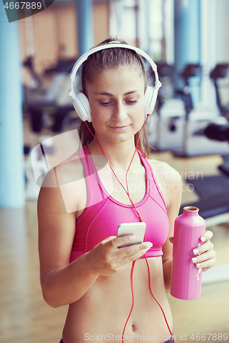 Image of woman with headphones in fitness gym