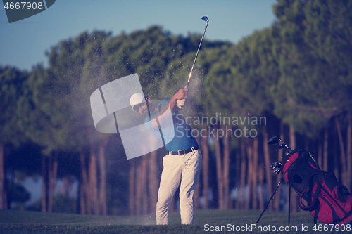 Image of golfer hitting a sand bunker shot on sunset