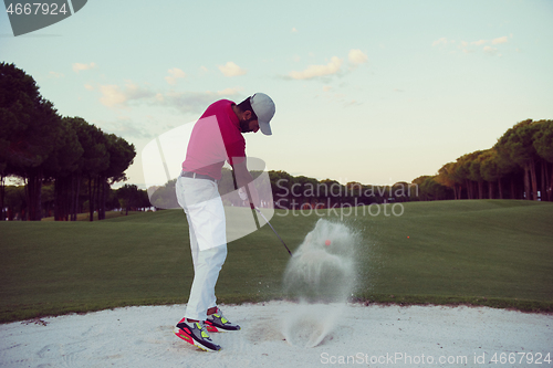 Image of golfer hitting a sand bunker shot on sunset