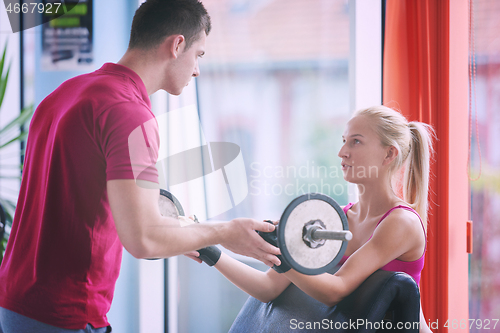 Image of young sporty woman with trainer exercise weights lifting