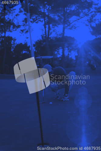 Image of golf player aiming perfect  shot on beautiful sunset