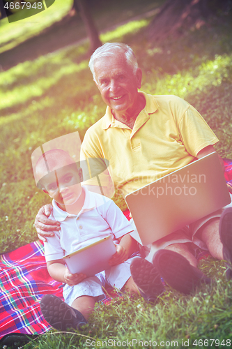 Image of grandfather and child using laptop