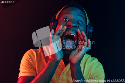 Image of The young handsome hipster man listening music with headphones