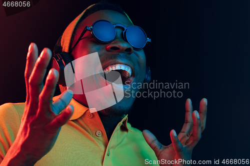 Image of Young handsome hipster man listening music with headphones