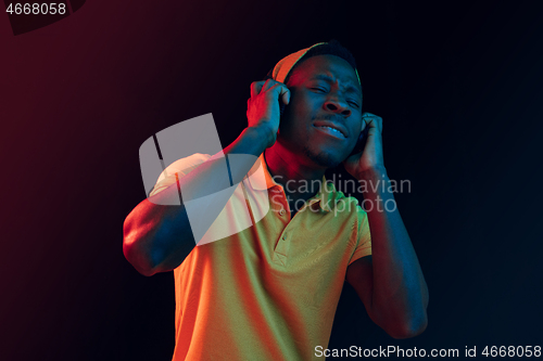 Image of The young handsome hipster man listening music with headphones