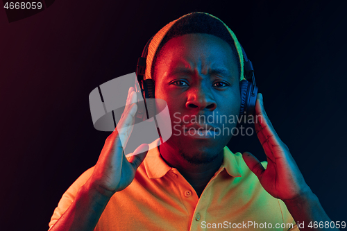 Image of The young handsome hipster man listening music with headphones