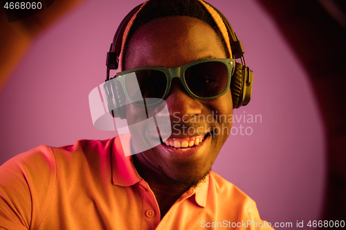 Image of The young handsome hipster man listening music with headphones