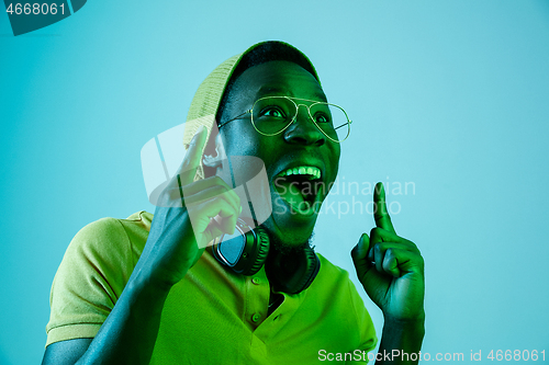 Image of The young handsome hipster man listening music with headphones